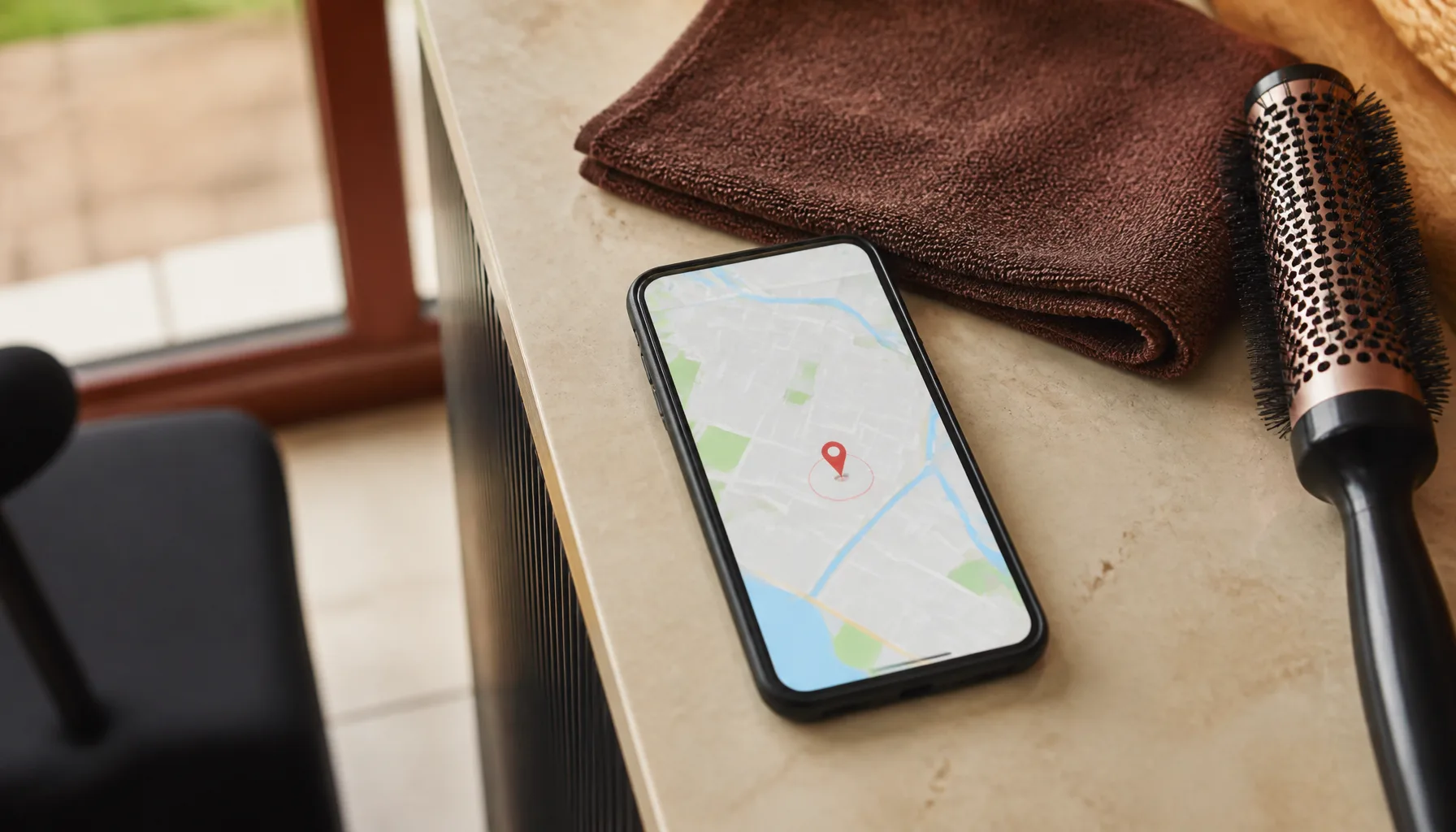 Salon tezgahında duran telefon ekranında, tek bir konum işareti etrafına çizilmiş dar yarıçaplı hedefleme alanı